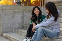 Two women sitting on the steps of the Liberal Arts Center.