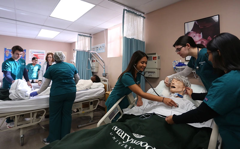 Nursing student in lab learning with mannequins