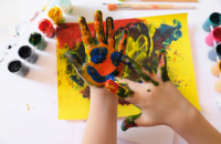 A smiley face is painted on a child's inner palm.