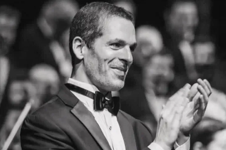Black and white photo of a man in a tuxedo clapping