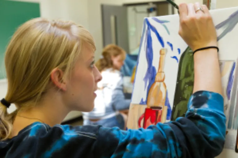 student painting in studio arts