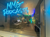 green and blue lit room with microphones, screens and lights