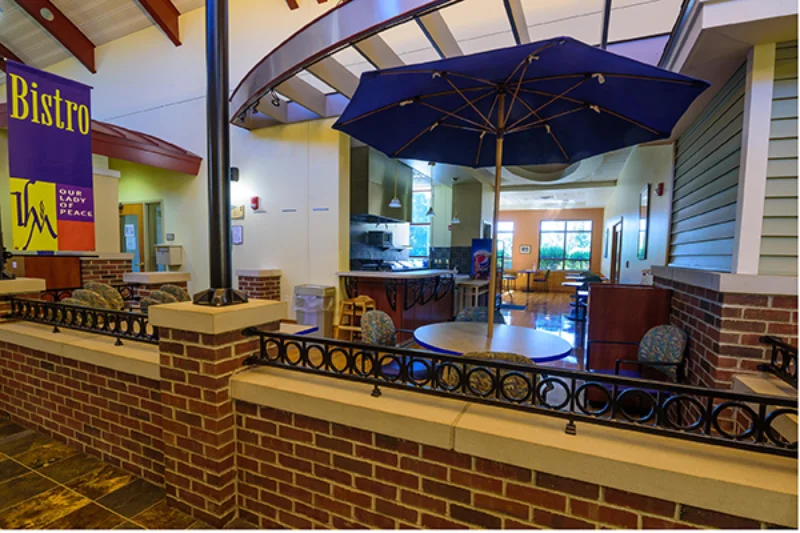 A purple umbrella covers a table inside the Bistro