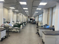 long room full of exam beds with mannequins acting as patients