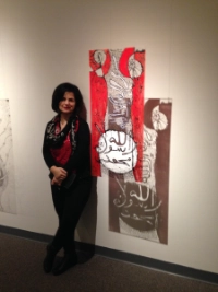 Poshya Kakil Ahmed stands next to her exhibit at the University
