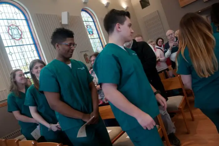 a line of nursing students in line to participate in the Blessing of the Hands ceremony.